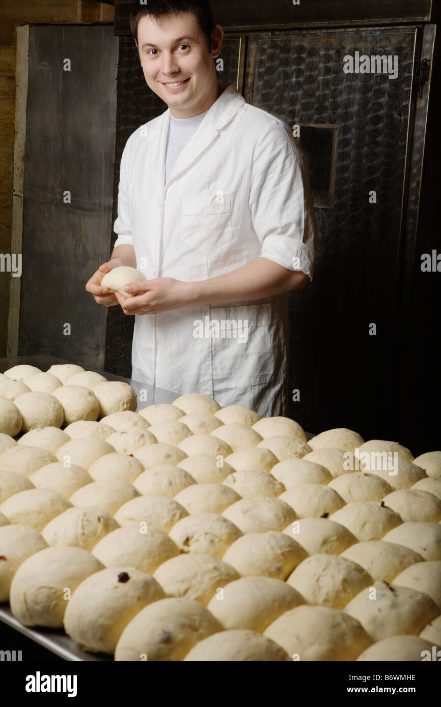 Baker con bolas de masa de pan listo para hornear Foto de stock