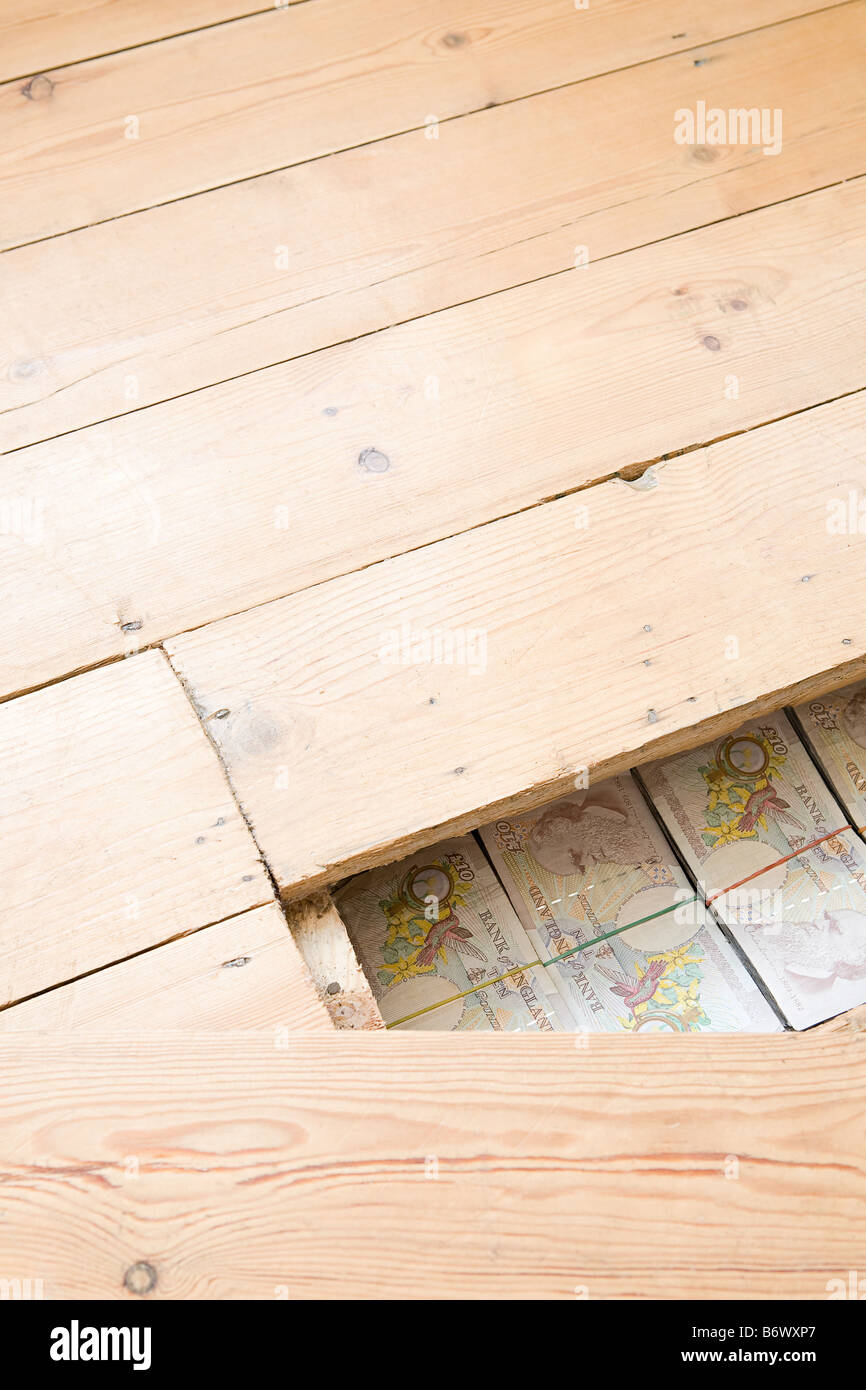 Dinero escondido bajo el suelo de madera Foto de stock
