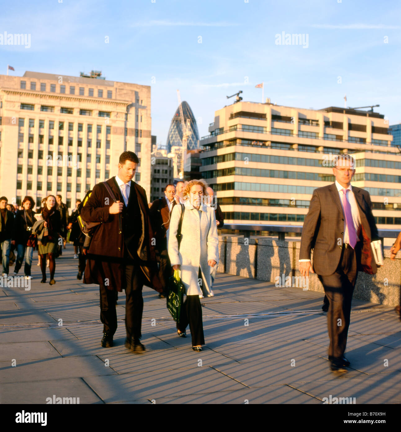 La gente caminando a casa desde el trabajo en otoño cruzando el Puente de Londres con vista de pepinillo edificio de Londres Inglaterra KATHY DEWITT Foto de stock