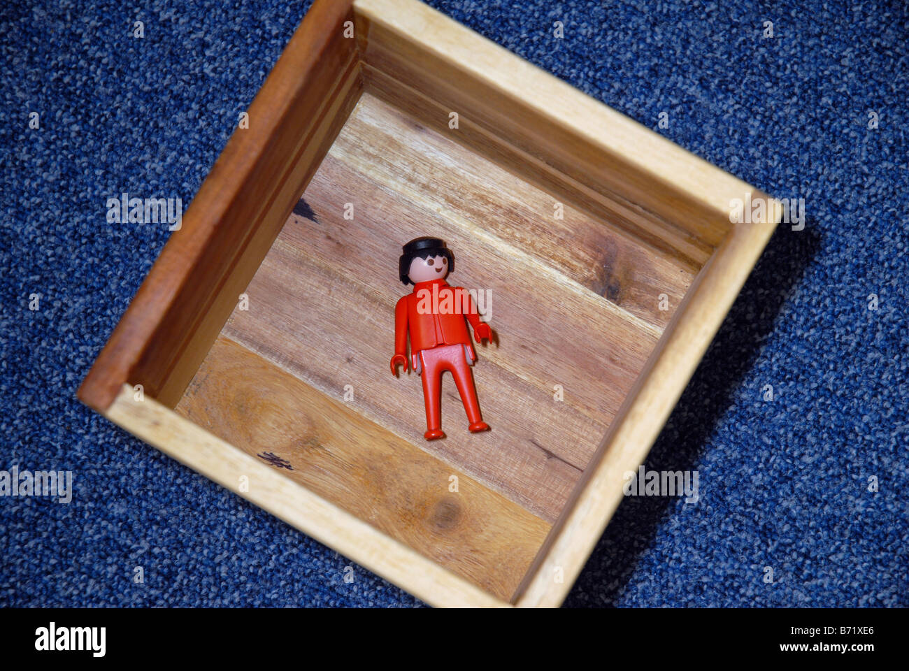 Juguete o modelo sentado dentro de una caja de madera. Sugiere el concepto  empresarial de pensar dentro y fuera de la caja Fotografía de stock - Alamy