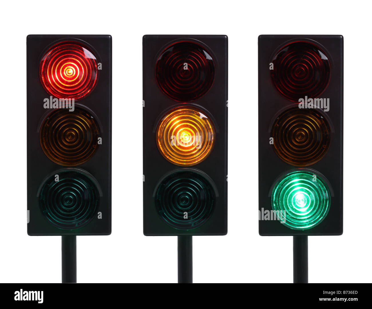 Tres semáforos en rojo amarillo y verde luces recortadas sobre fondo blanco. Foto de stock