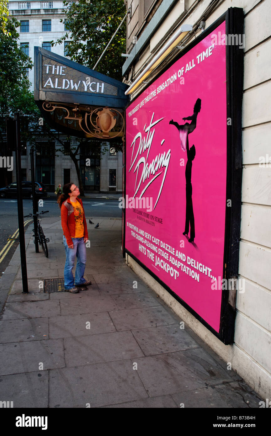 Una joven mujer mirando un gran cartel de la representación teatral de "Dirty Dancing" Foto de stock