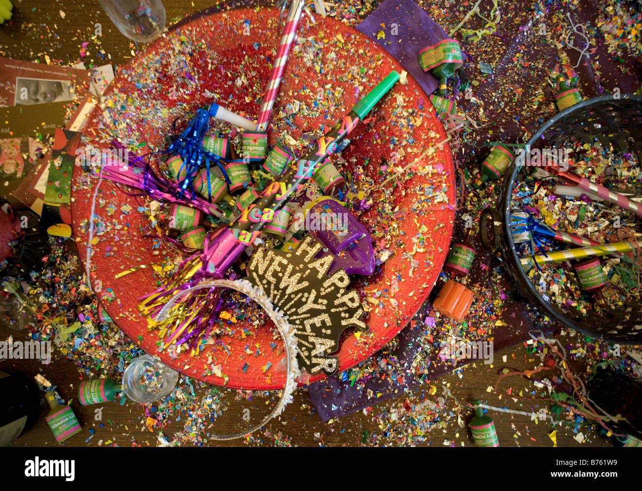 Fiesta de Año nuevo naufragio incluyendo confeti poppers cuernos serpentinas matasuegras copas de champaña y sombreros Foto de stock