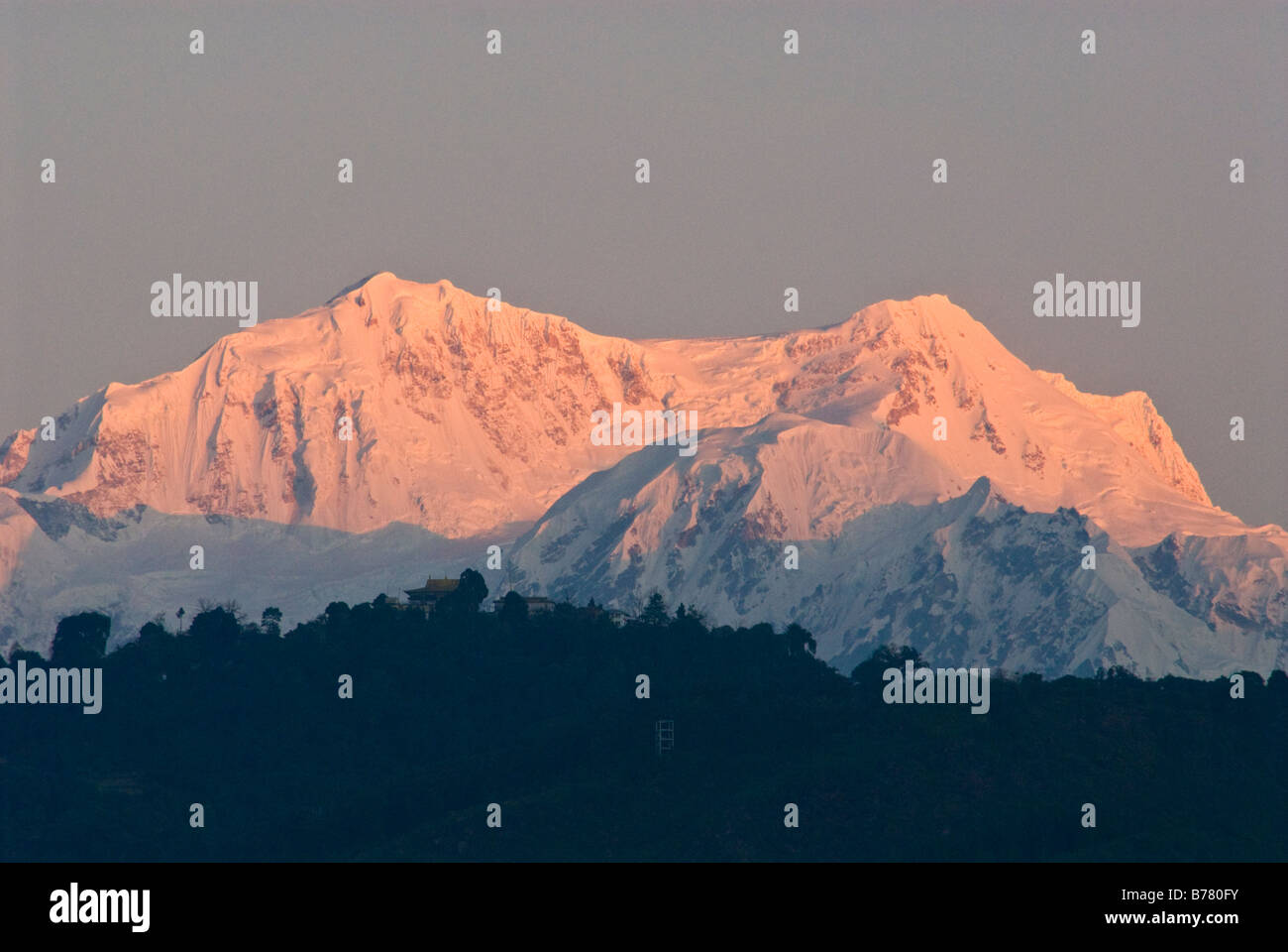 Los picos de la cordillera Kangchenjunga, Sikkim, al amanecer. Monasterio Pemayangtse puede verse en la cima de una colina, en el primer plano. Foto de stock