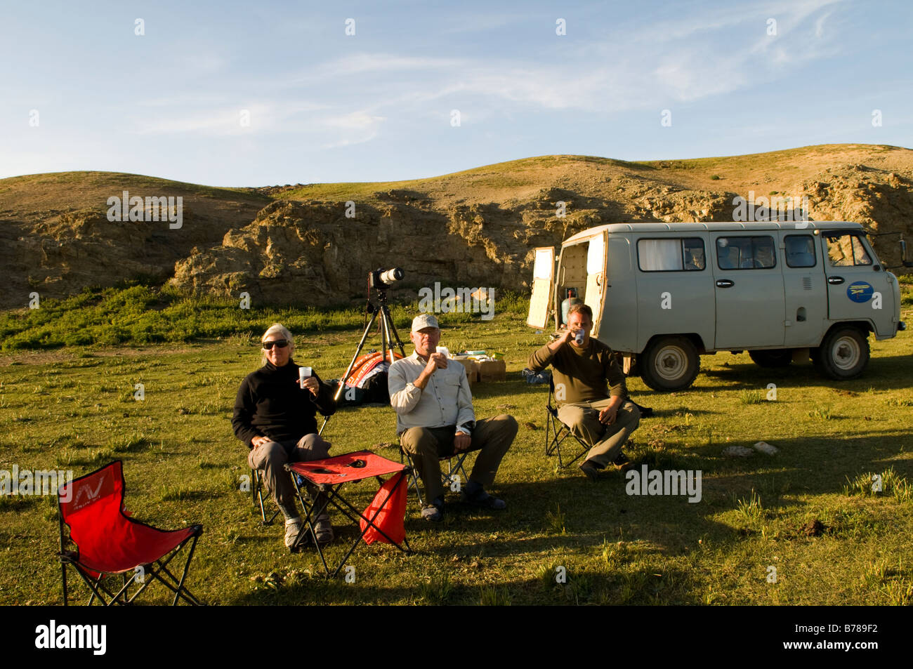 los viajeros disfrutan de una copa de vino después de un largo día. Foto de stock