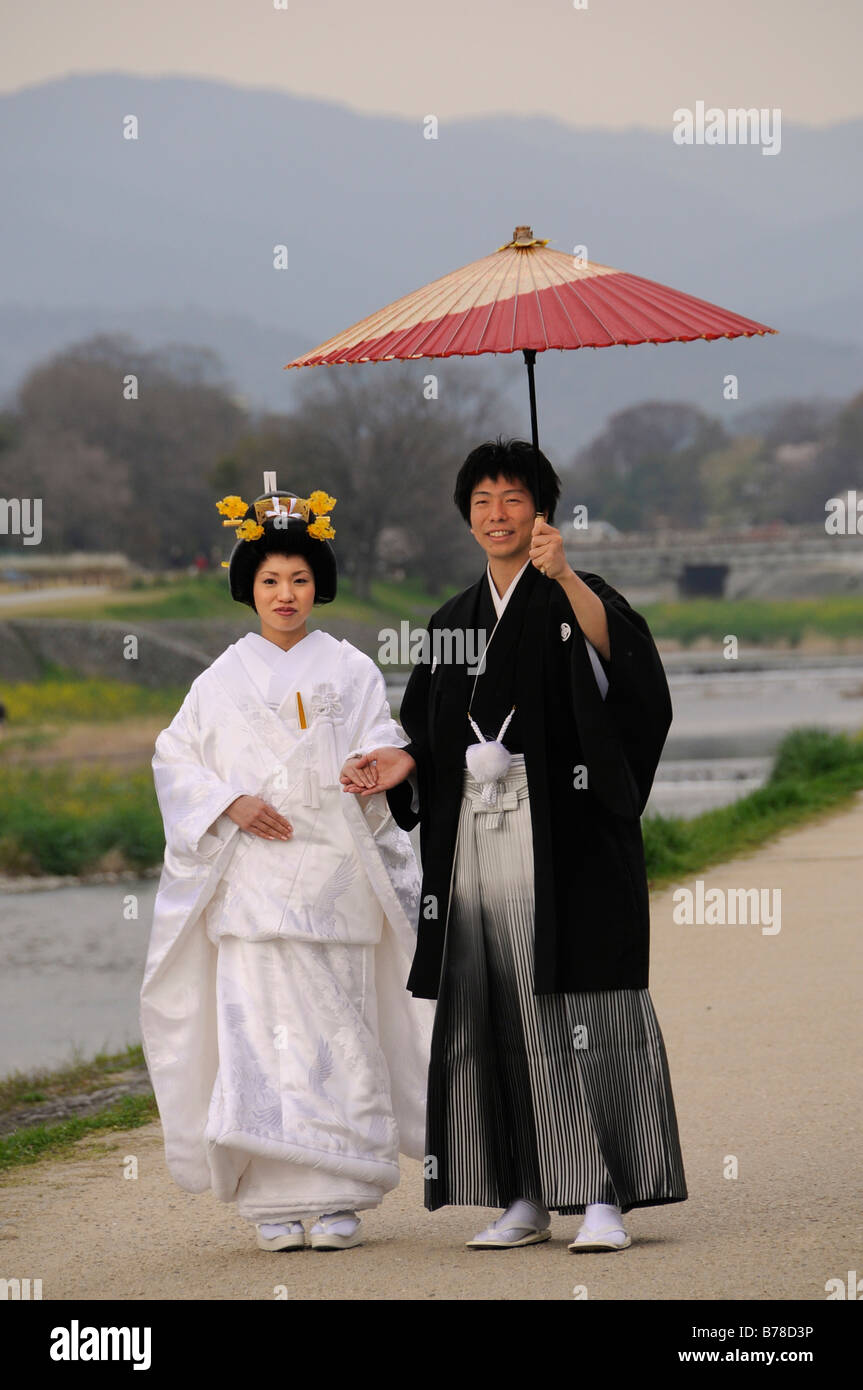 Pareja de boda tradicional japonesa vistiendo kimonos, novia boda con el  peinado, el novio sosteniendo una sombrilla de papel tradicional en  Fotografía de stock - Alamy