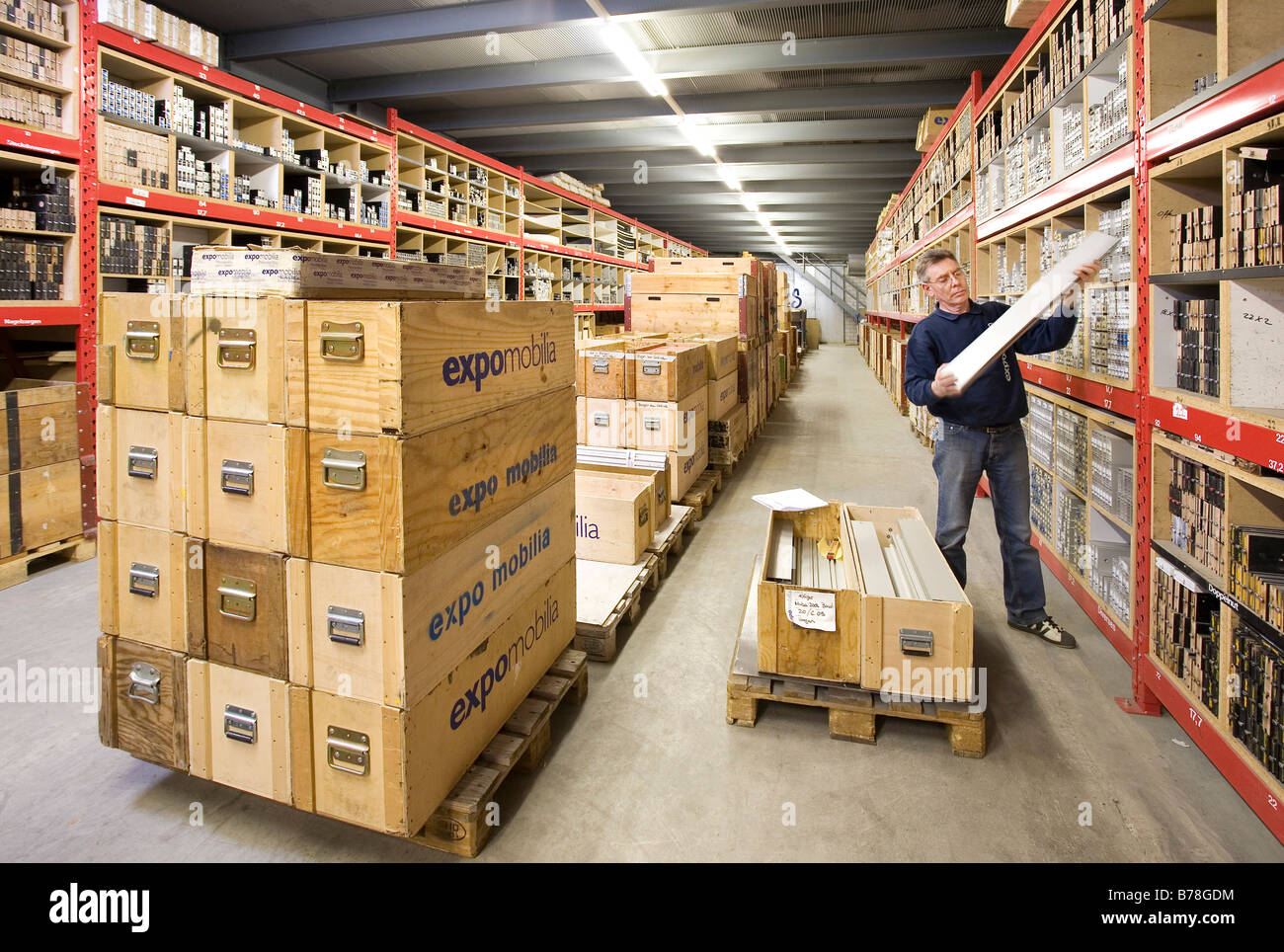 Warehouse Manager para la empresa Expomobilia que construye edificio de clasificación de puestos de exhibición de material en la sala de almacenamiento, Foto de stock