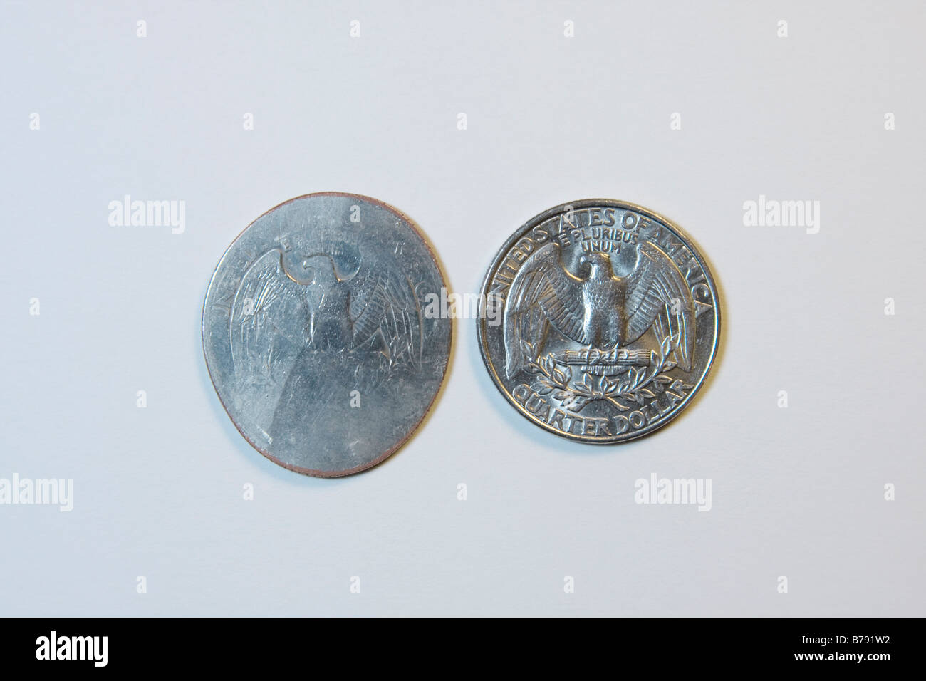 Moneda de Estados Unidos. Dos de veinticinco céntimos. Uno de ellos fue arrollado por un tren. Foto de stock