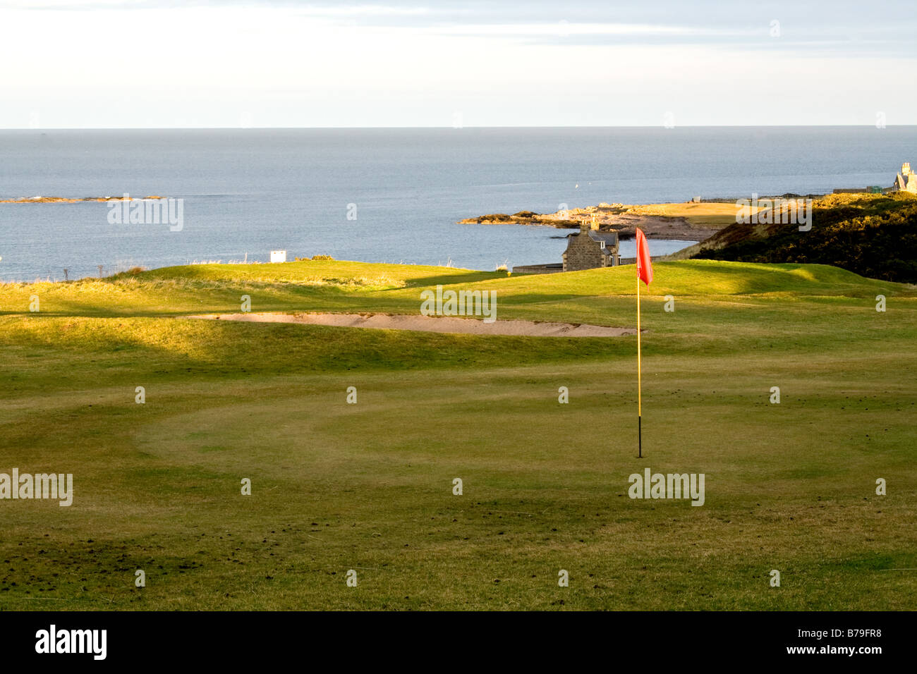 Agujero con bandera en un campo de golf con vistas a Moray Firth en Buckie, Escocia Foto de stock
