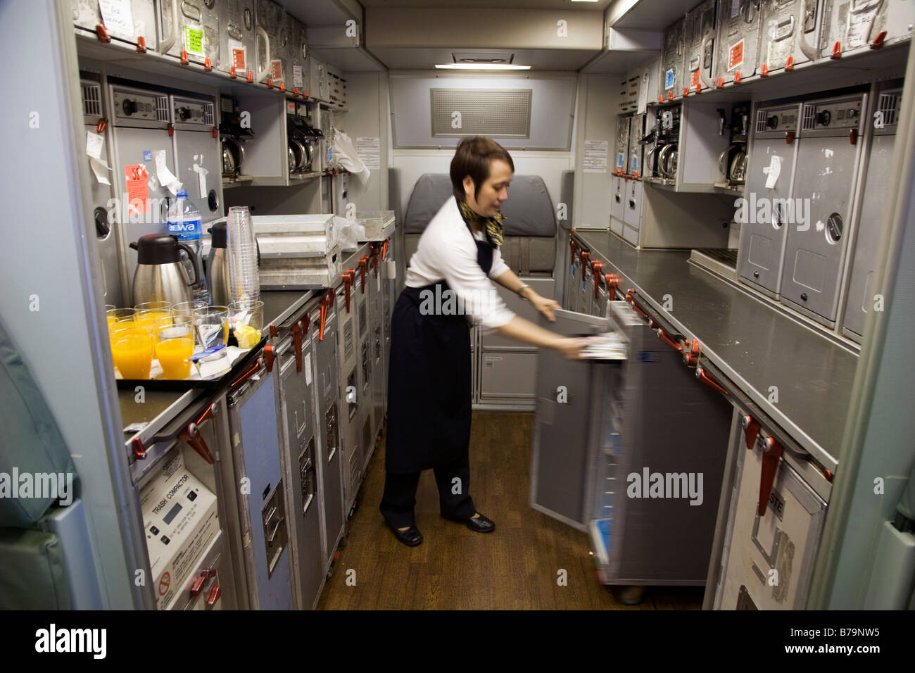 Miembro de la tripulación de cabina trabaja en la cocina en un Airbus A330 de Gulf Air de la aeronave durante el vuelo desde Londres a Bahrein. (45) Foto de stock