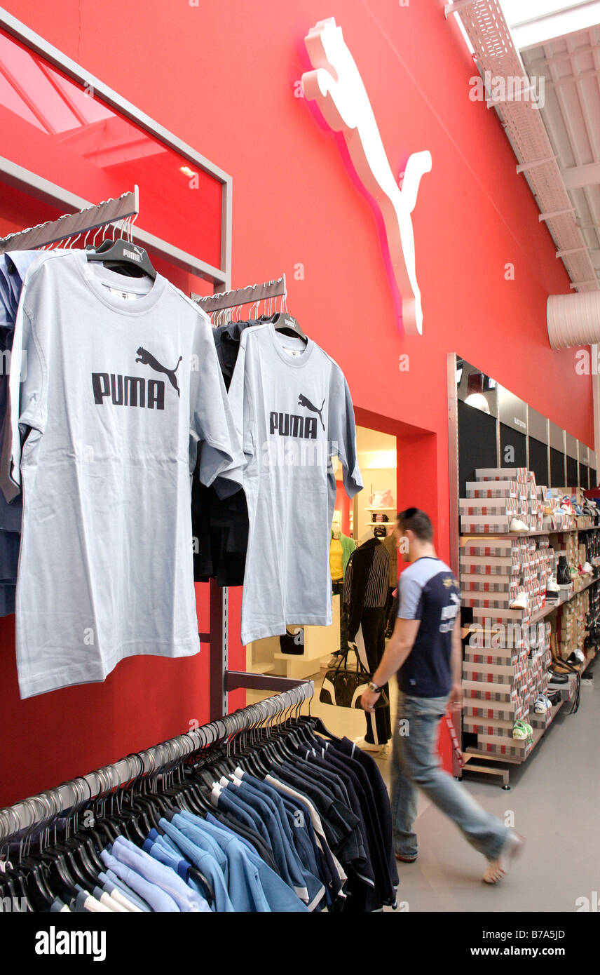 Camisetas con el logotipo de Puma en la tienda outlet de Puma en Herzogenaurach, Baviera, Alemania Foto de stock