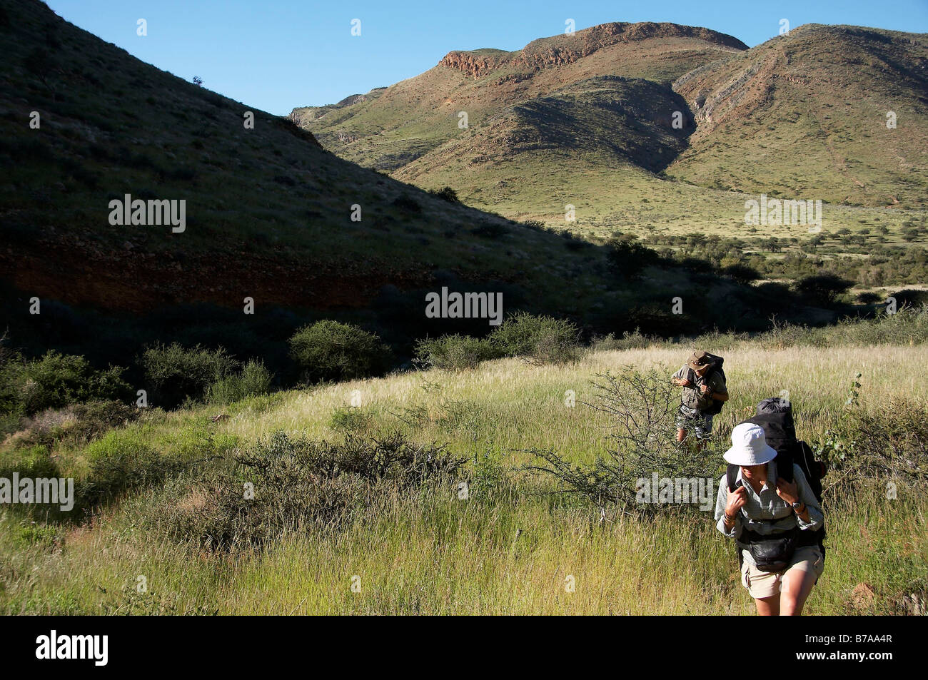 Dos adolescentes de excursionistas en una cresta rocosa teniendo en la vista Foto de stock