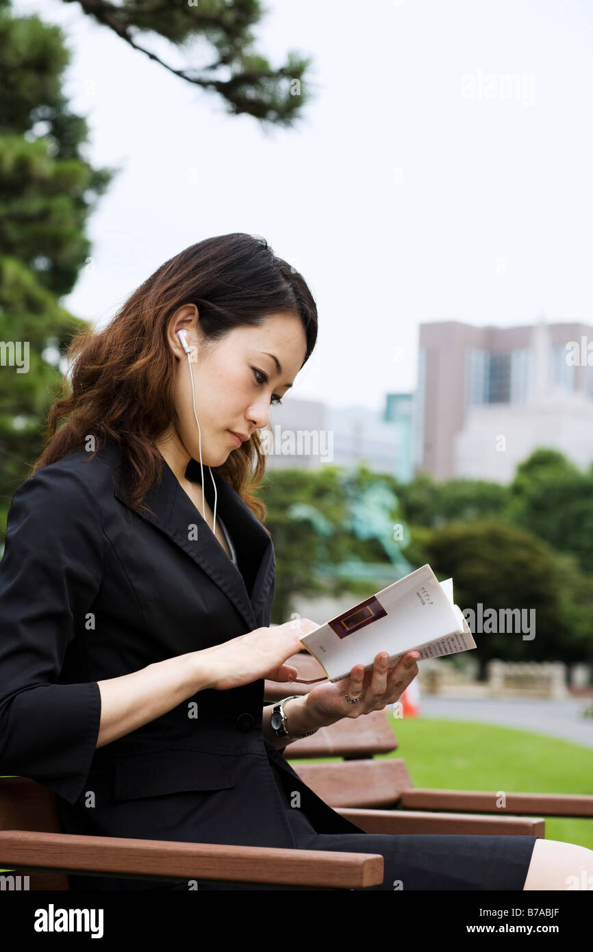 Joven Mujer Asiática leyendo un libro en el parque, Tokio, Japón, Asia Foto de stock
