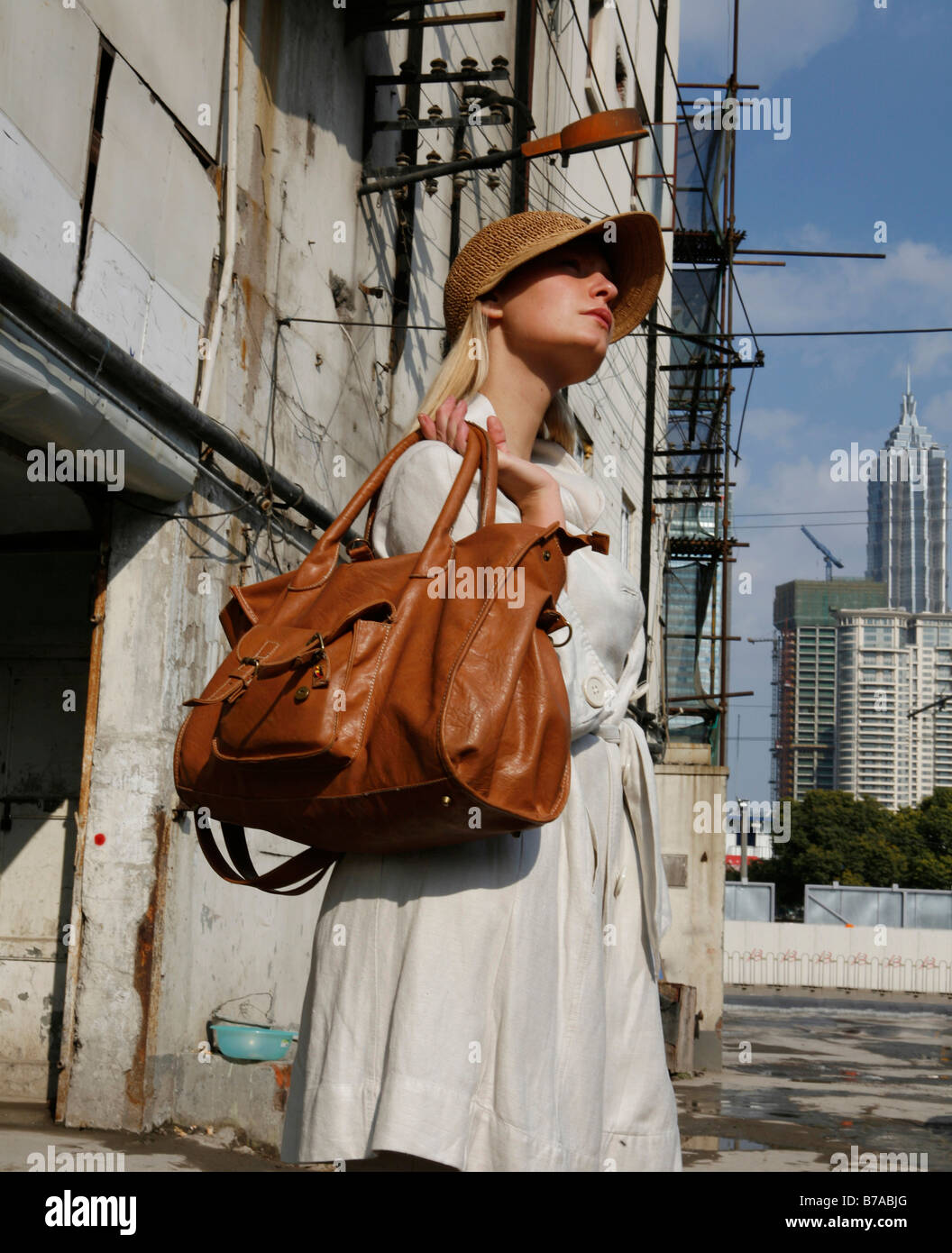 Mujer joven con un bolso, detrás de ella la Torre Jin-Mao, Shanghai, China, Asia Foto de stock