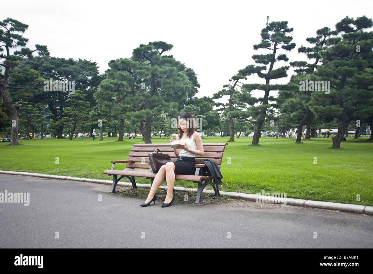 Joven comiendo en un parque, en Tokio, Japón, Asia Foto de stock