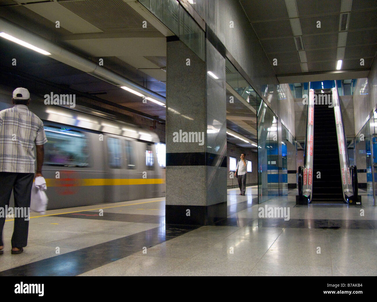 Una plataforma con un pasajero esperando un tren que llega en el sistema de Metro de Delhi. Delhi. La India. (45) Foto de stock
