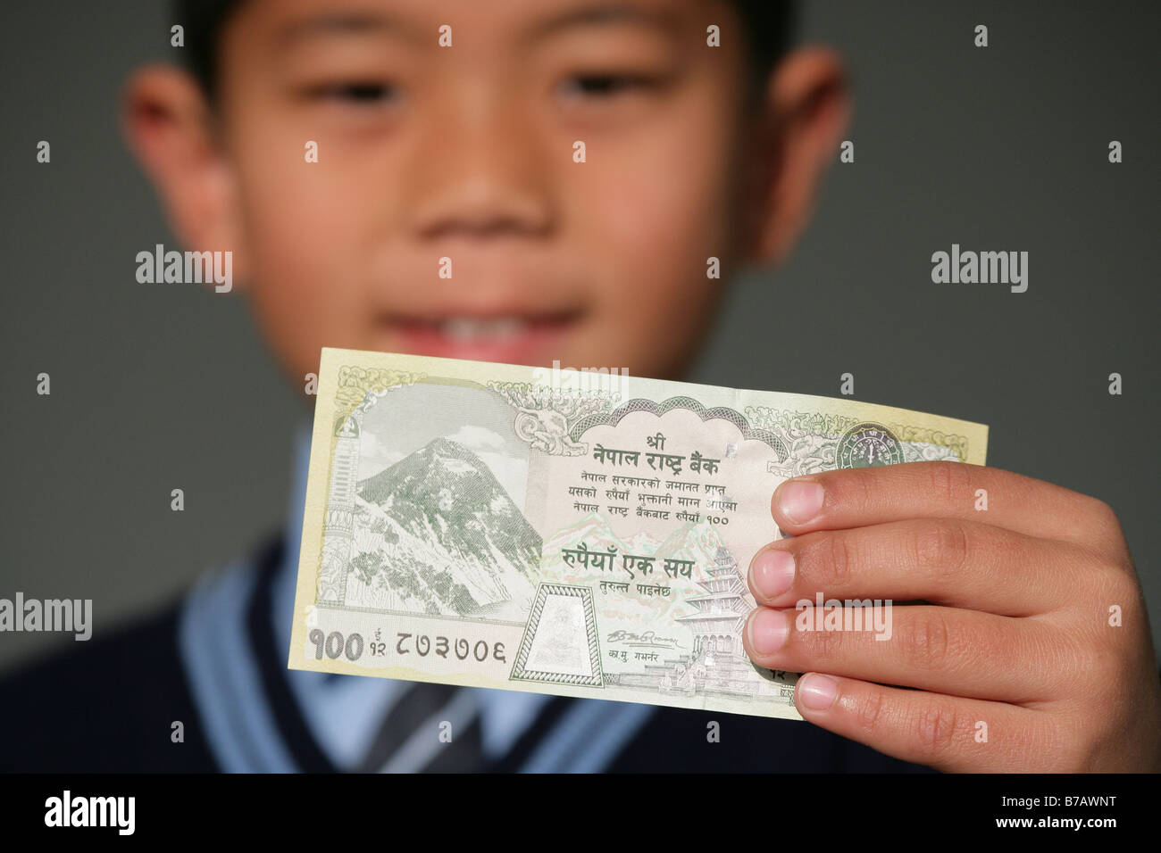"Nepaleses de niños sosteniendo un cien rupia nota". Foto de stock