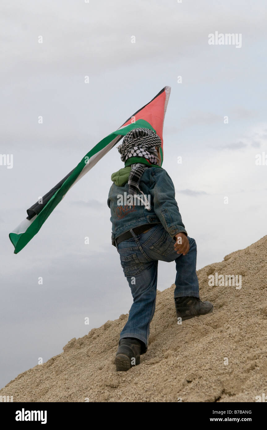 Niño beduino sostiene la bandera palestina en la aldea de Negev Ar'arat-Naqab durante una protesta contra Israel continúa la operación militar en Gaza Foto de stock