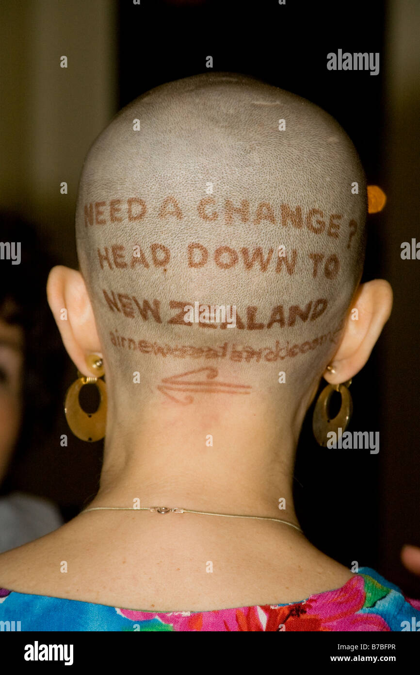 Un agente de viajes de Los Ángeles lleva un anuncio de Nueva Zelandia en la parte de atrás de su cabeza rapada. Foto de stock