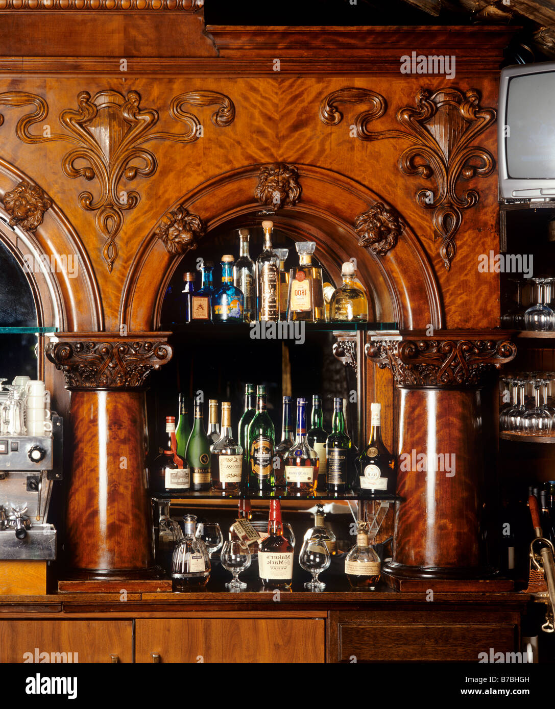 Un bar de servicio completo, con fachada de madera tallada suministra una gama completa de libaciones Foto de stock