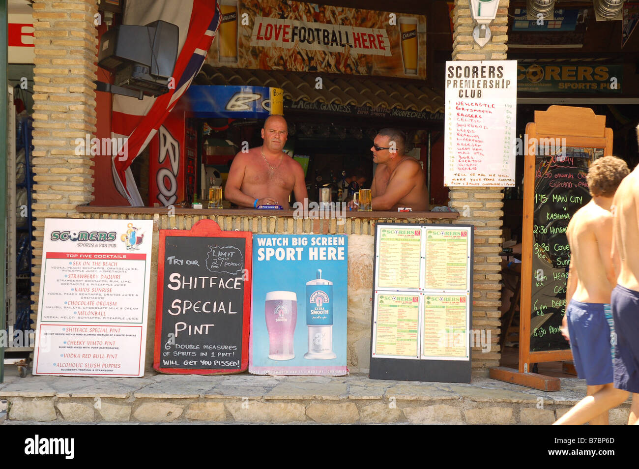 Dos hombres curtidos en inglés disfrutando de su pinta en un día caluroso en Cavos, Corfú. Foto de stock