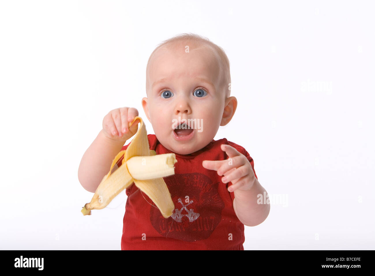 Niño está asustado de un plátano en una piel Foto de stock