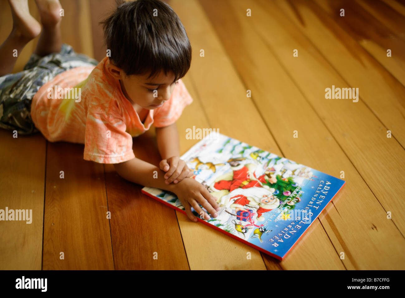 Seis años de edad reside en el piso y abre las puertas al calendario de adviento Foto de stock