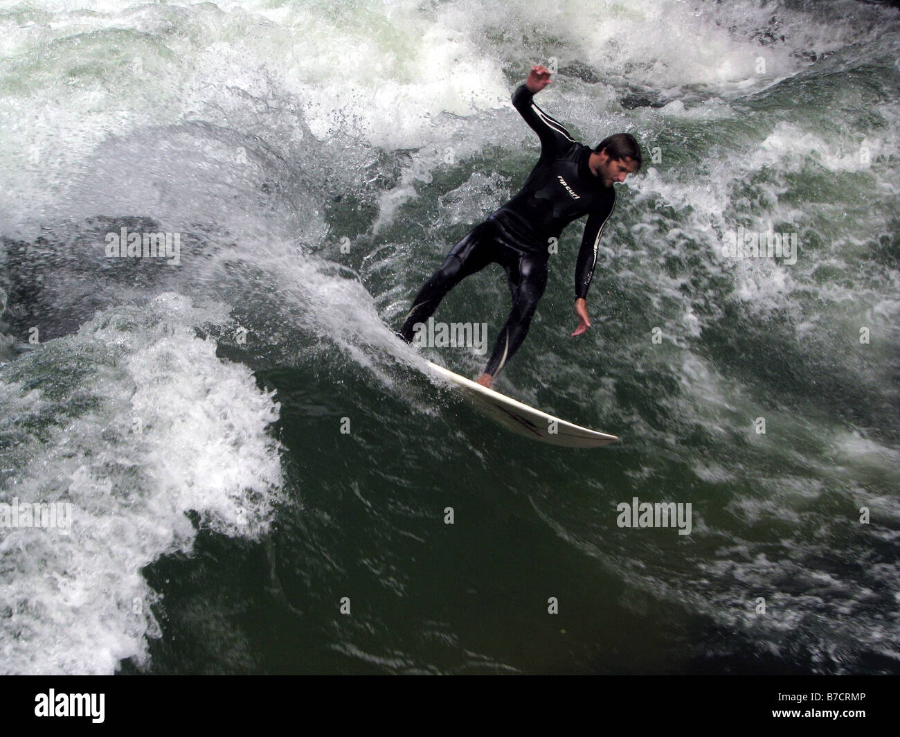 Surfer en los llamados 'tehende Welle" (standing wave) del Eisbach (rama del río Isar) en el Jardín Inglés, el germen Foto de stock