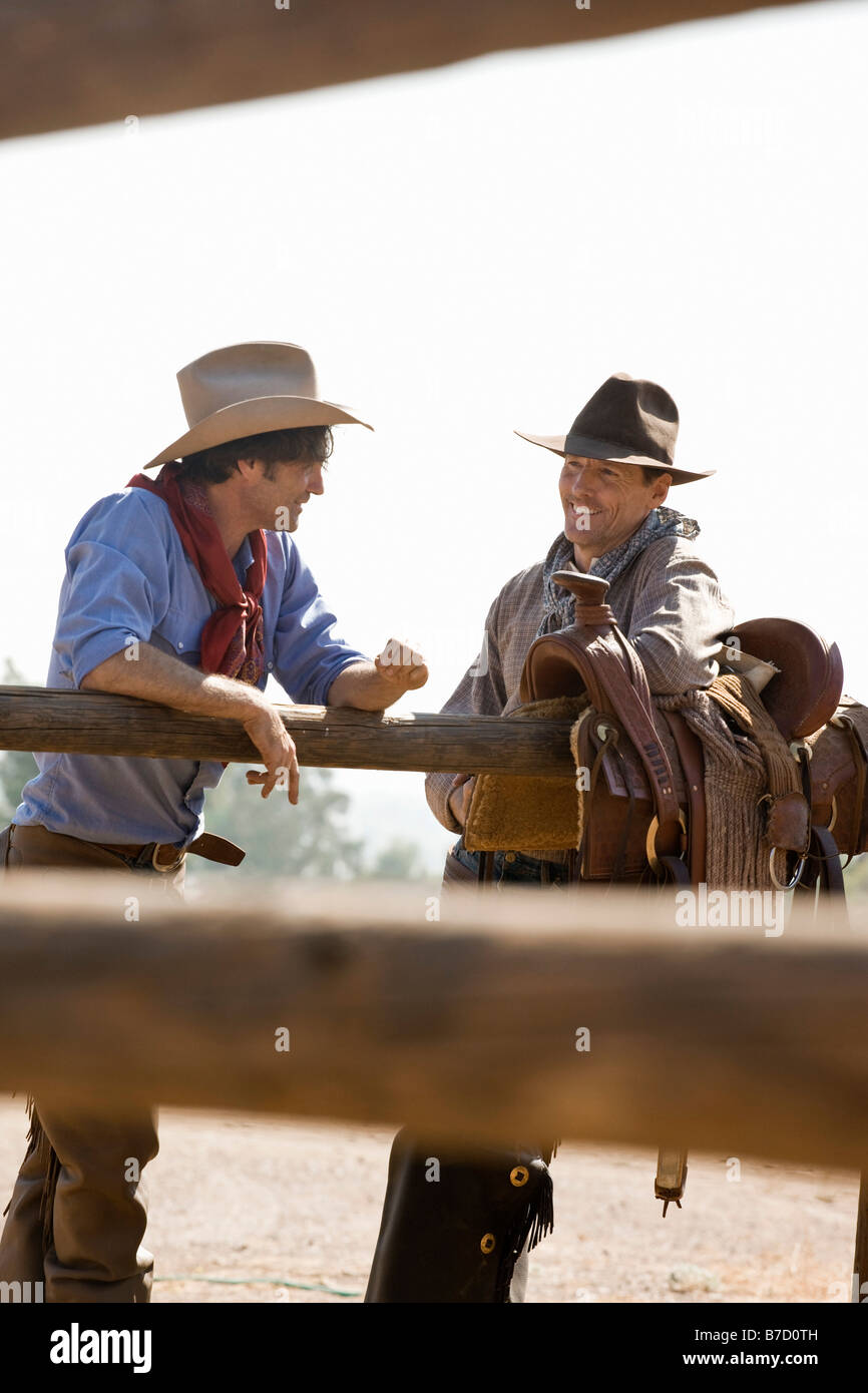 Dos rancheros hablando junto a una valla Foto de stock