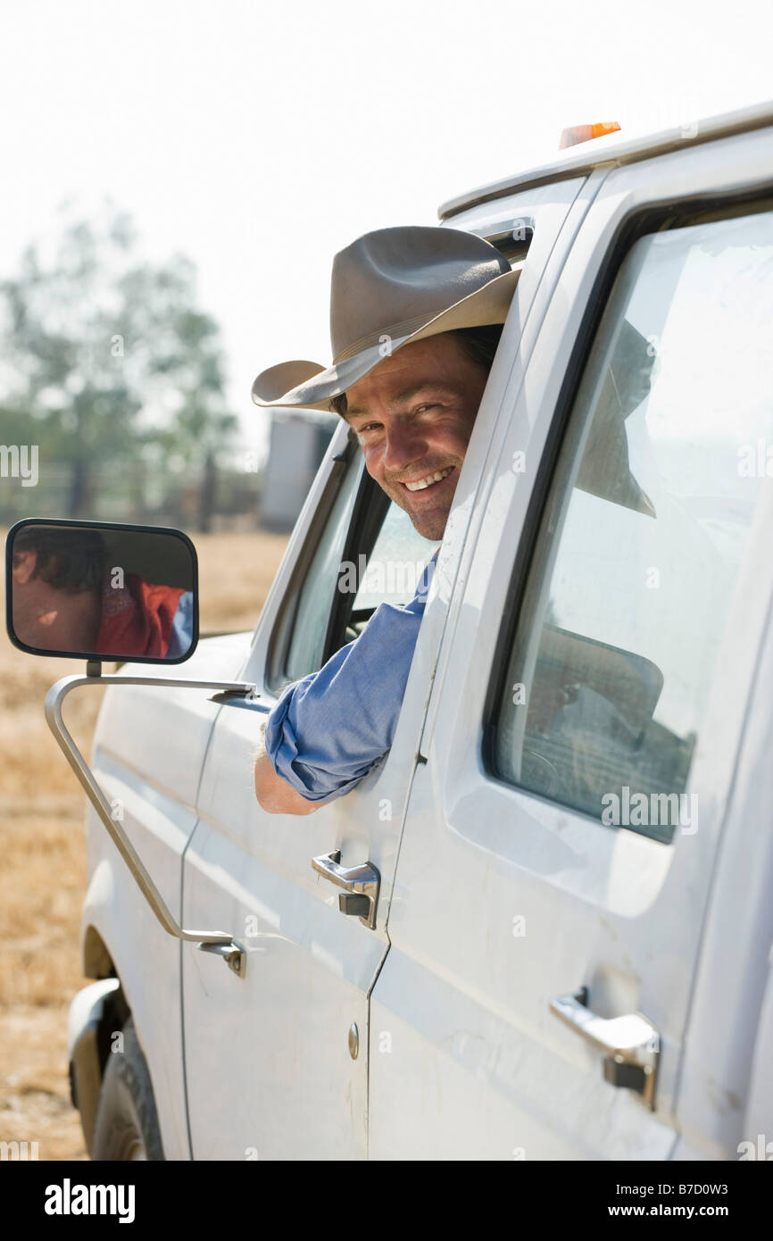 Un hombre que mira desde la ventana de su camión y sonriente Foto de stock