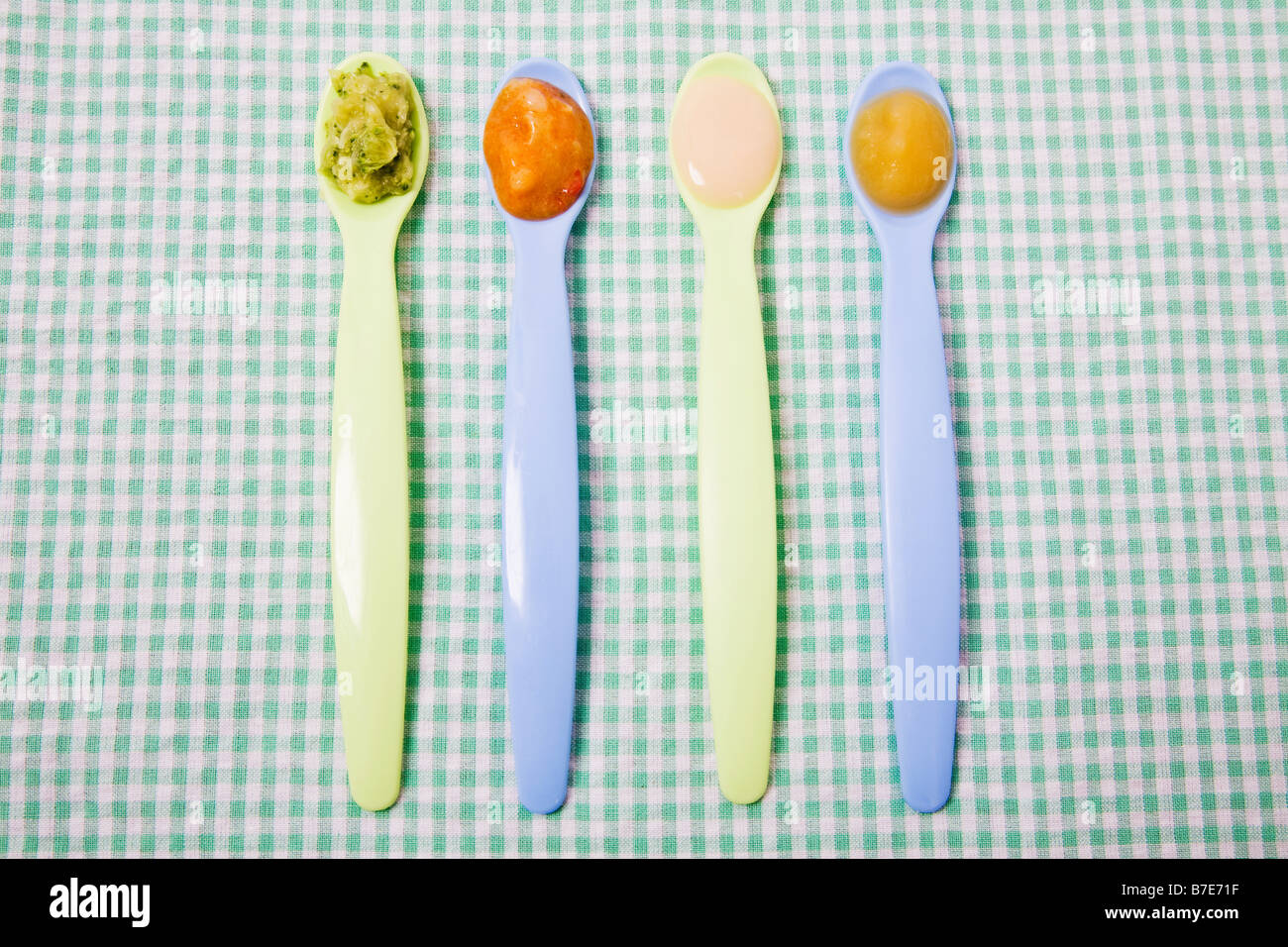 La comida del bebé en cucharas Foto de stock