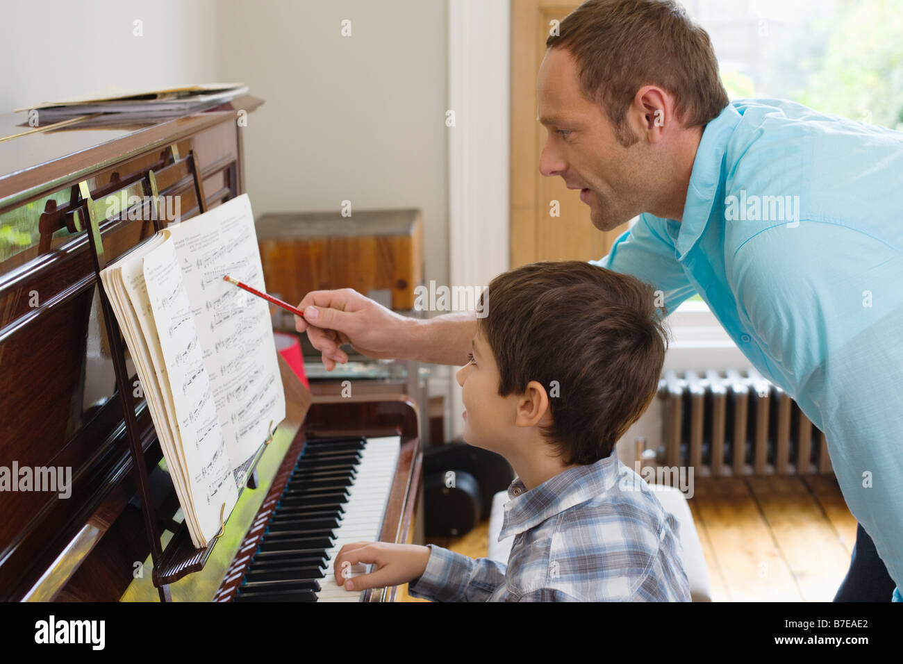 Hijo de padre enseñar cómo tocar el piano Fotografía de stock - Alamy