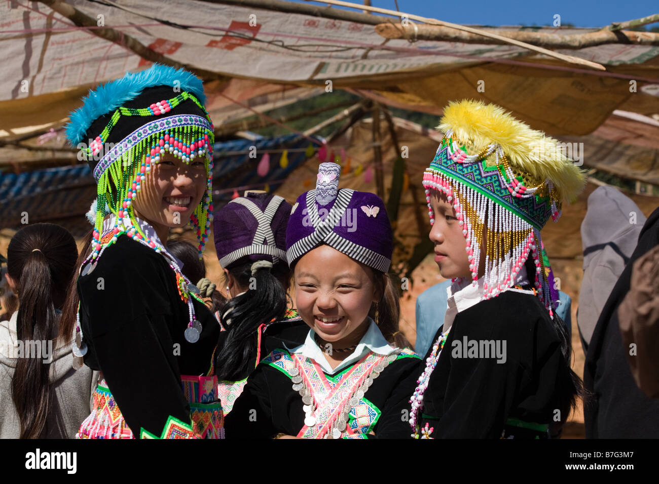 Tres jóvenes chicas Hmong, vestida con un traje tradicional, posan para una fotografía en una ceremonia de Año Nuevo hmong rural. Foto de stock