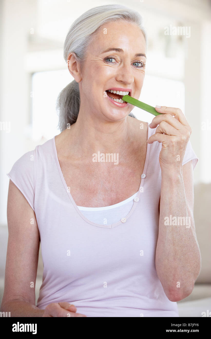 Mujer mayor comiendo apio Stick Foto de stock