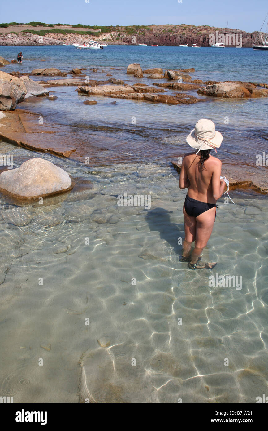 Mujer vacaciones-maker vadeando en el Mediterráneo, cerca de Carloforte en la isla de San Pietro, Cerdeña, Italia Foto de stock
