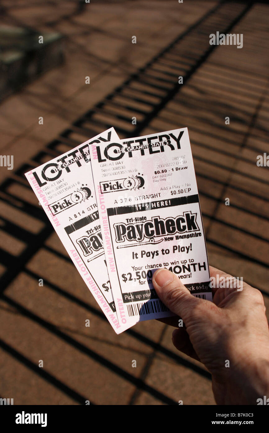 Mano sosteniendo par de New Hampshire Pick 3 lotería estatal. Foto de stock
