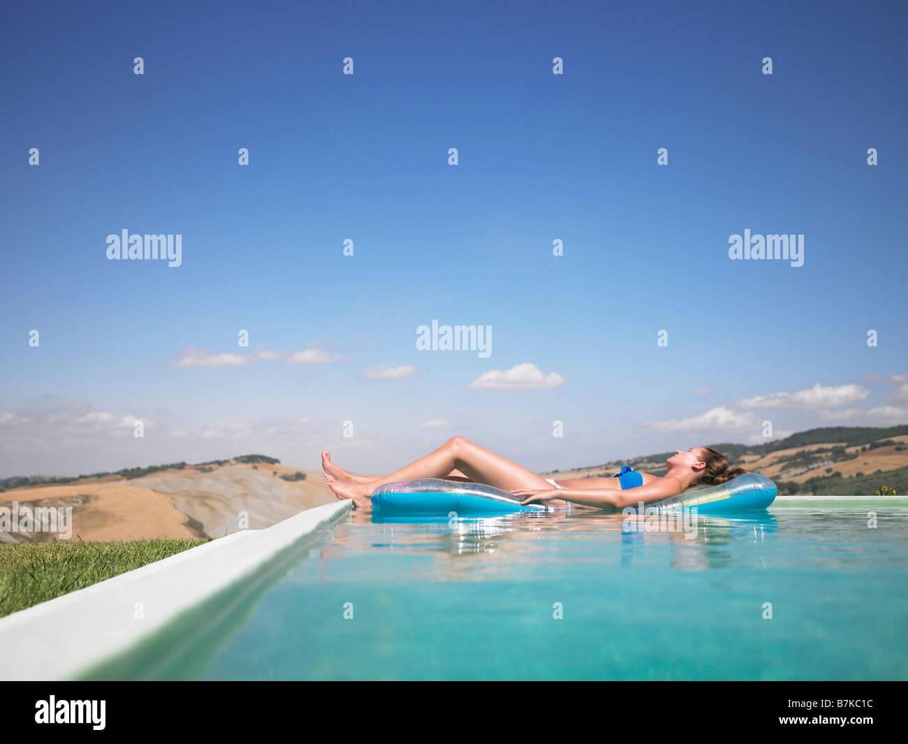 Mujer descansando en la piscina Foto de stock