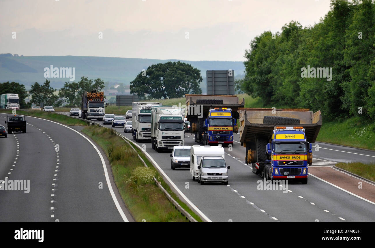 Transporte pesado camión que transportaba un gigante volquetes amplia carga anormal en la autopista Foto de stock