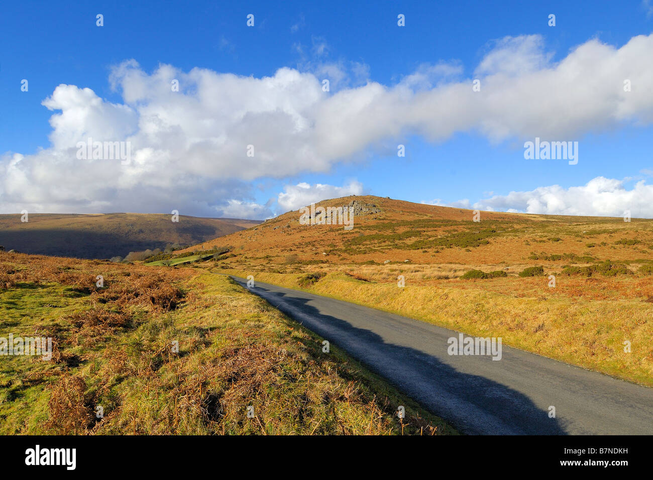 Un país de una sola vía angosta carretera cerca de rocas Bonehill en Dartmoor con Chinkwell Tor en la media distancia Foto de stock