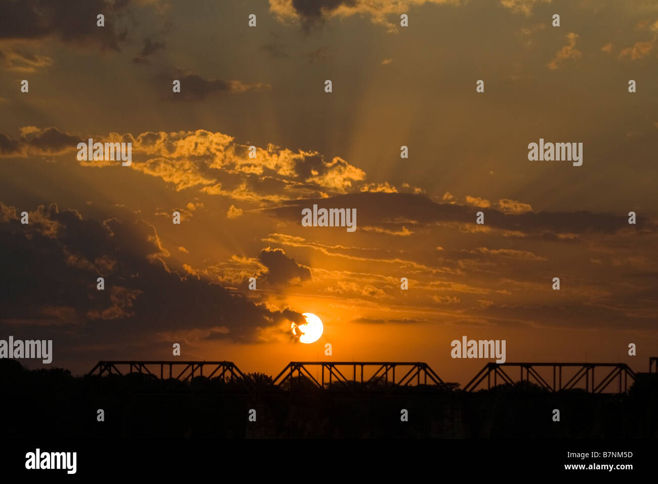 Puesta de sol sobre el viejo puente ferroviario en Skukuza, el Parque Nacional Kruger, Sudáfrica Foto de stock