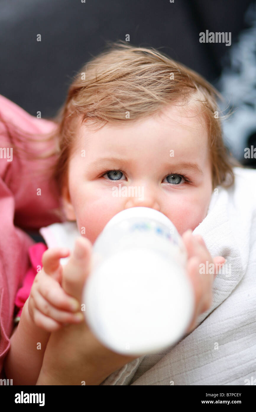 Una niña se alimentados con biberón por su madre Foto de stock