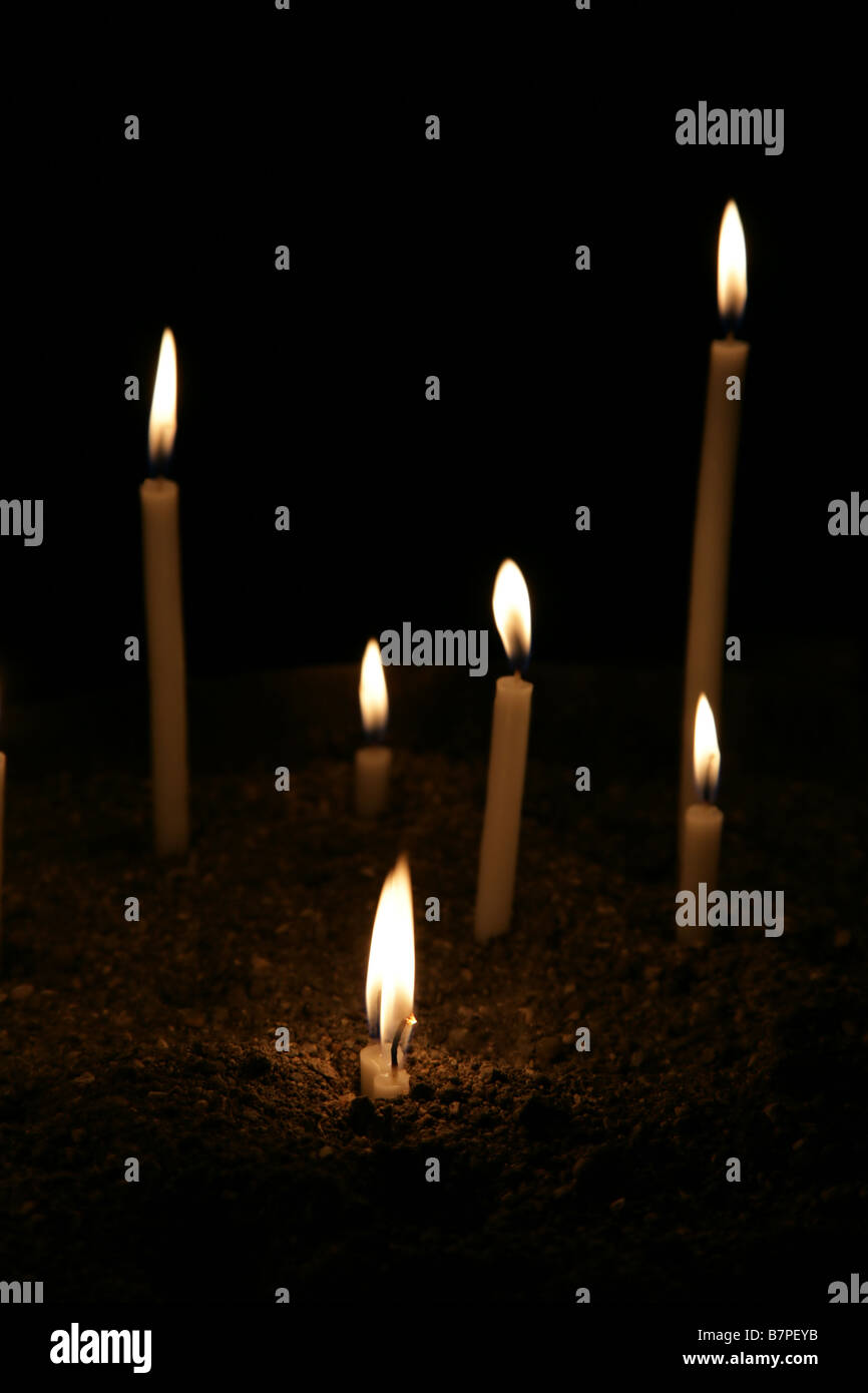 Unos conflagrant velas en la oscuridad Foto de stock
