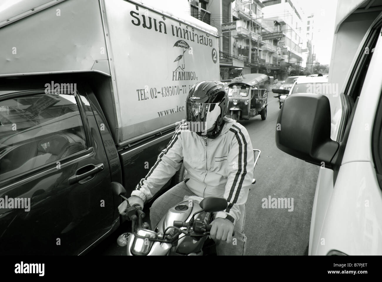 Hombre en moto atascado en el tráfico Chinatown Bangkok Thailand Foto de stock