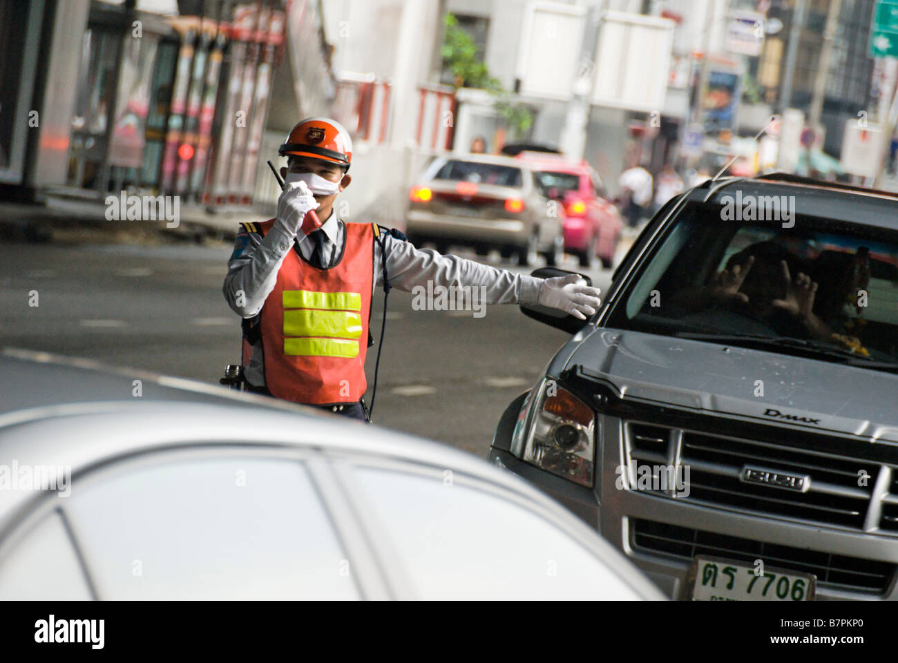 Aparcacoches dirigiendo el tráfico pesado Pathumwan distrito central de Bangkok Thailand Foto de stock