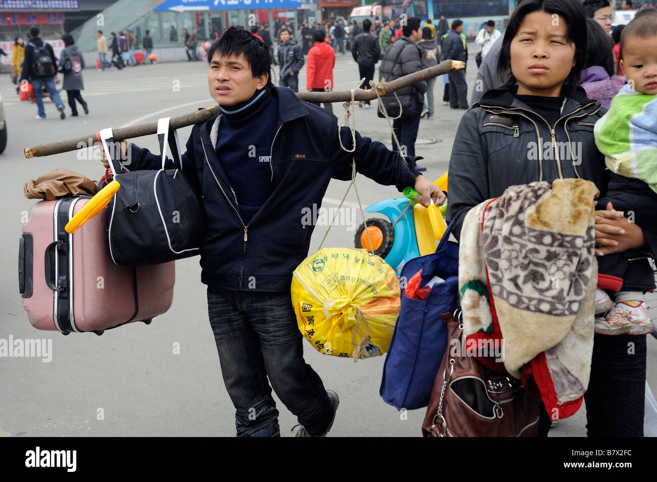 Los miembros de la familia migrante al salir de la estación de trenes de Nanchang, Jiangxi, China. 05-Feb-2009 Foto de stock