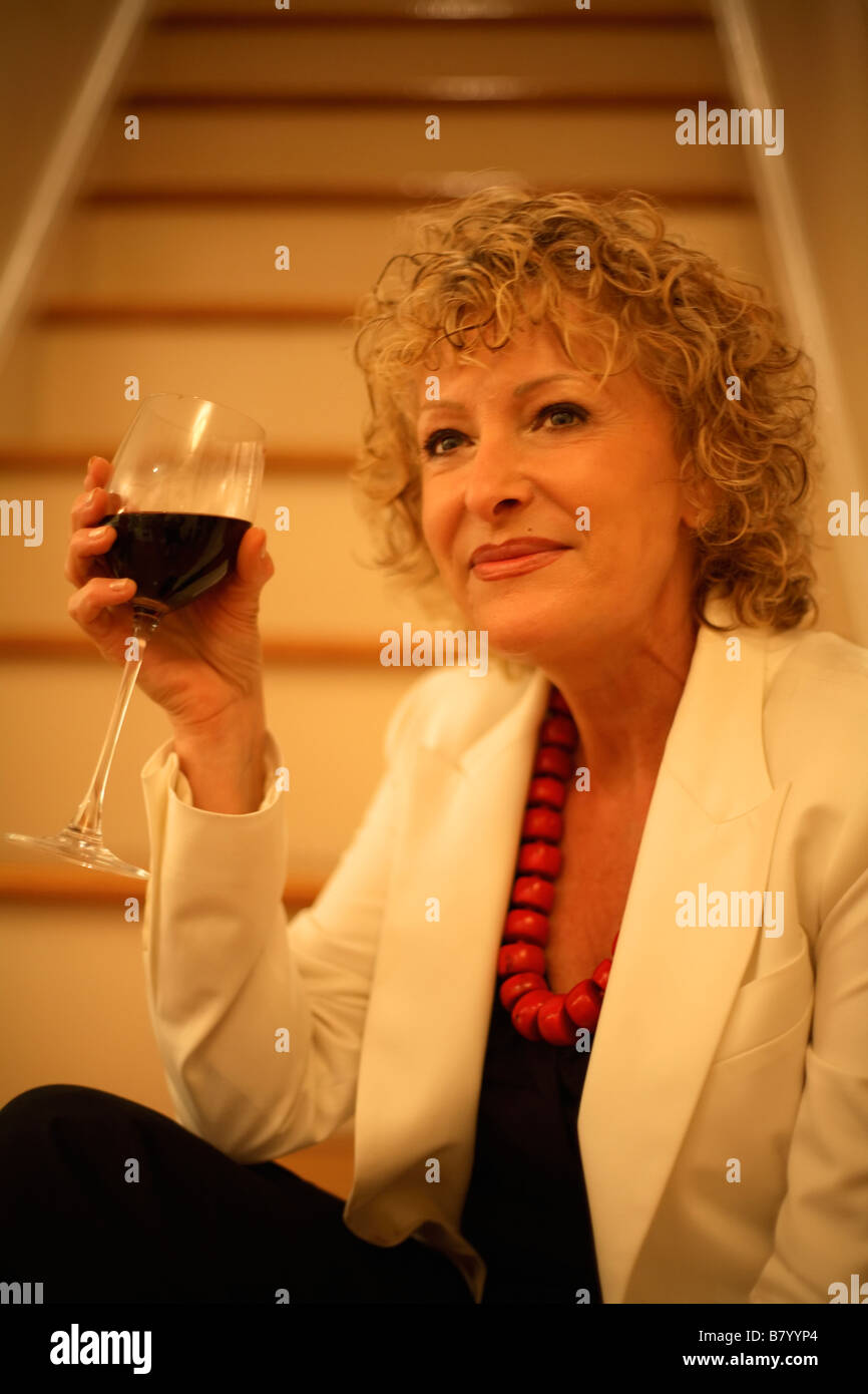 Senior mujer sosteniendo un vaso de vino tinto Foto de stock