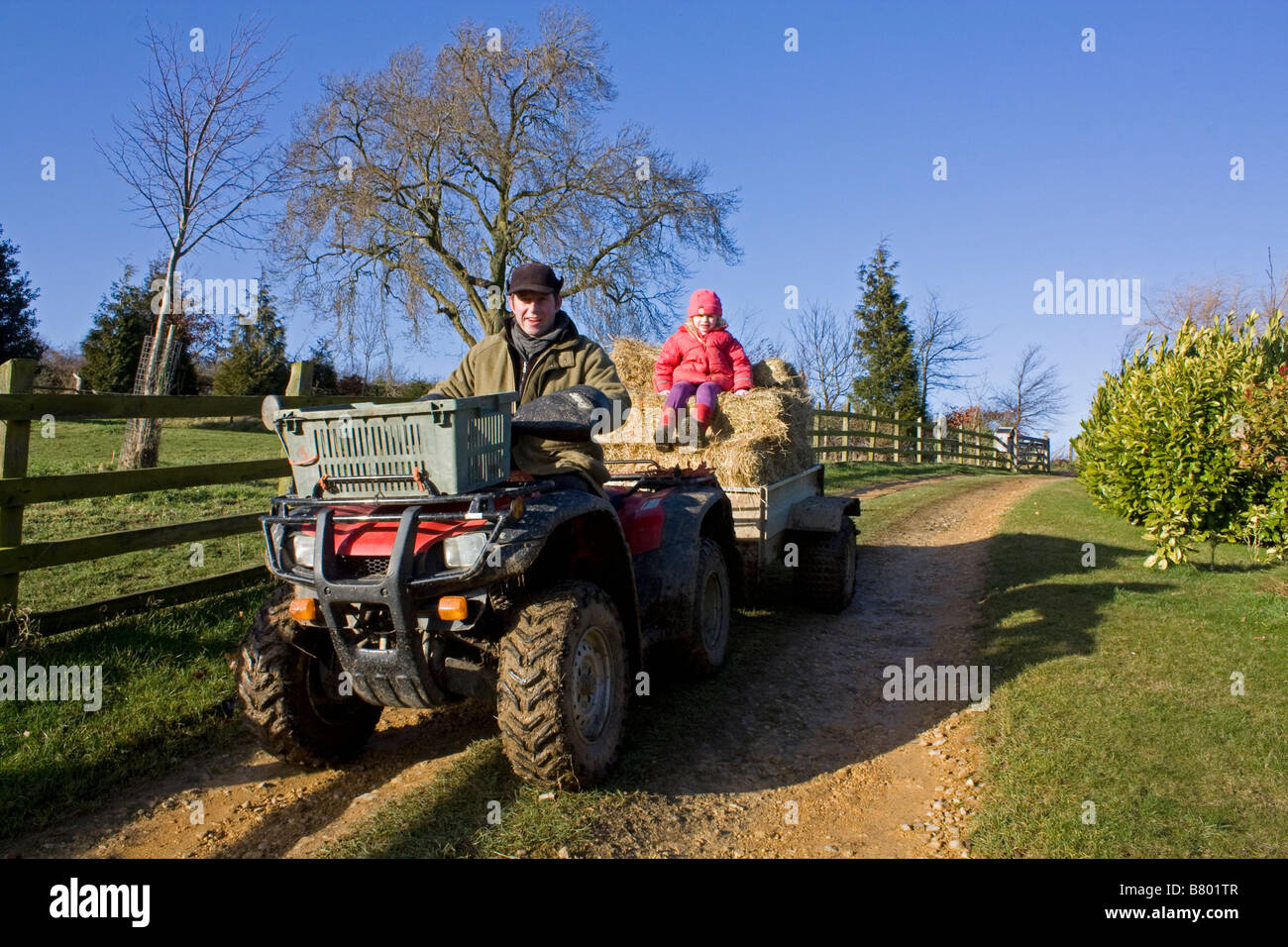 Niña y el padre en quad con remolque Fotografía de stock - Alamy