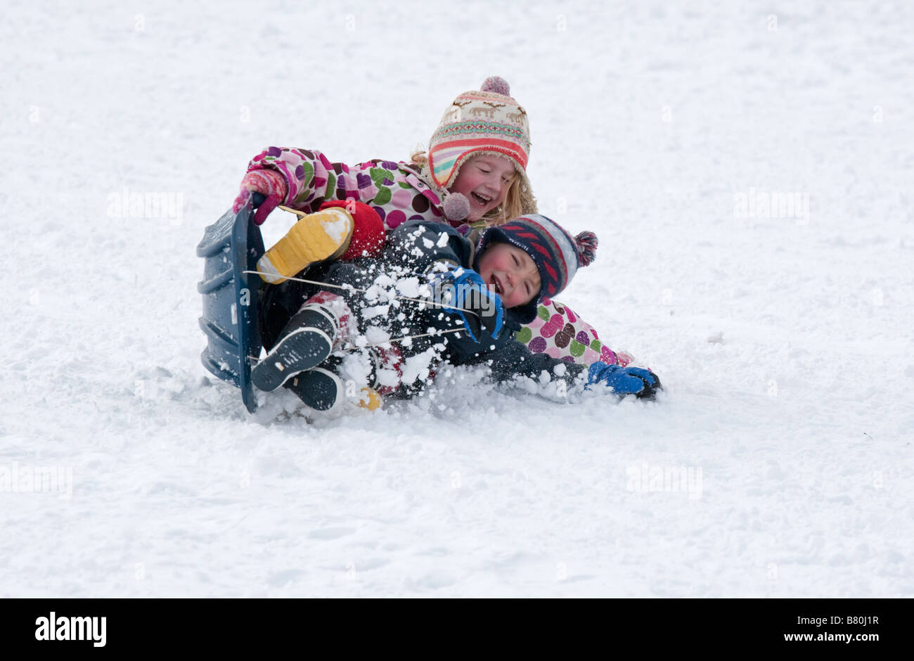 Niños En Los Trineos En Nieve Imagen de archivo - Imagen de lindo,  parientes: 4123093
