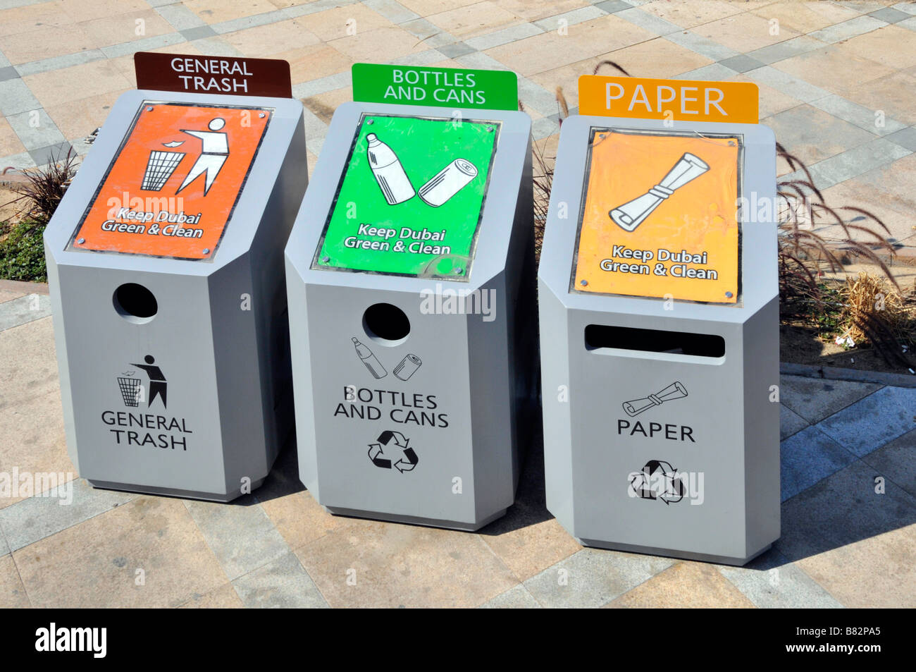 Dubai pavimento tres papeleras de reciclaje de basura para botellas, latas y papel basura general cada tolva codificadas por color Foto de stock