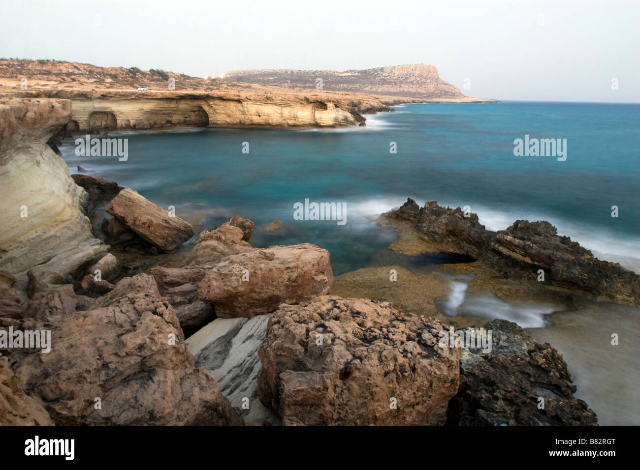 Vistas de las famosas cuevas del mar de Agia Napa en primer plano y Capo Greco en el fondo en la costa del sur de Chipre. Foto de stock